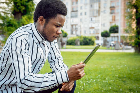 African student in the park. Beautiful backgroundの写真素材
