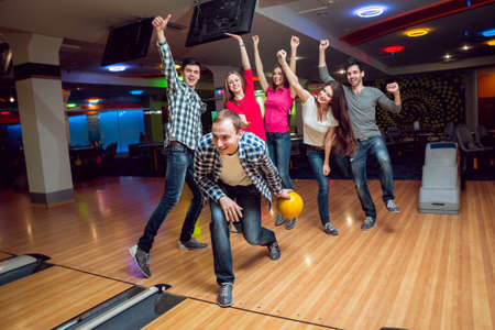 Cheerful friends at the bowling alley with the balls.の写真素材