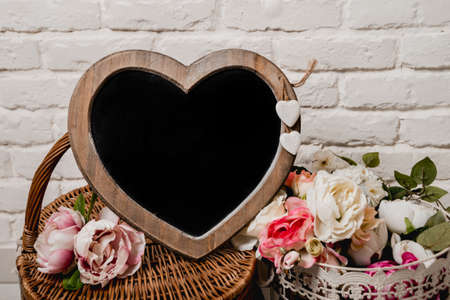 The frame as a heart with flowers on the wall.の写真素材