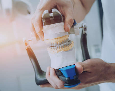 Dental technician working with articulator in dental labの写真素材