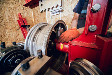 Professional car mechanic replace tire on wheel. Cleaning discの写真素材