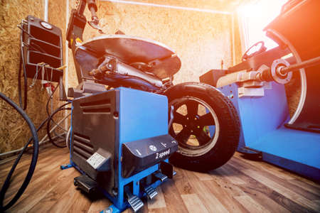 Professional car mechanic replace tire on wheel.の写真素材