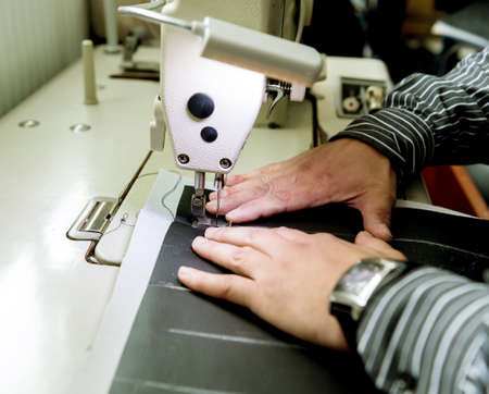 Designer tailor sew seat covers. Man use sewing machine for his work.の写真素材
