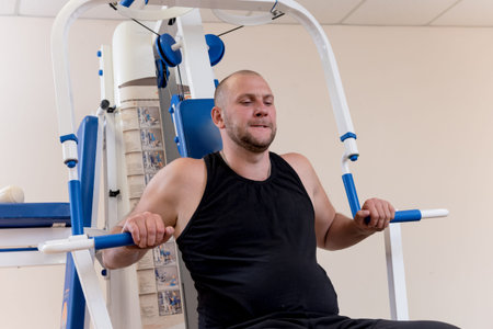 Disabled man doing strength exercises separate from the wheelchair.