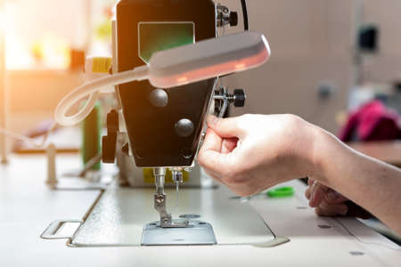 Designer tailor sew the dress. Woman use sewing machine for his work.の写真素材