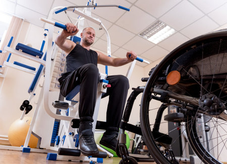 Disabled man doing strength exercises separate from the wheelchair.