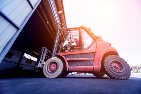 The big industrial forklift drives into the warehouse.