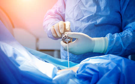 Surgeon performs endoscopic microdiscectomy of herniated intervertebral disc.の写真素材