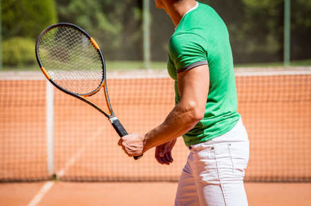 Young athletic couple playing tennis on the court.の写真素材
