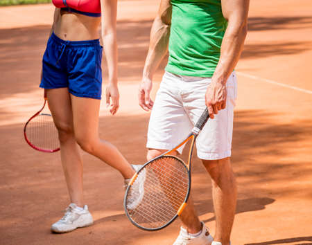 Young athletic woman playing tennis with her coach.の写真素材