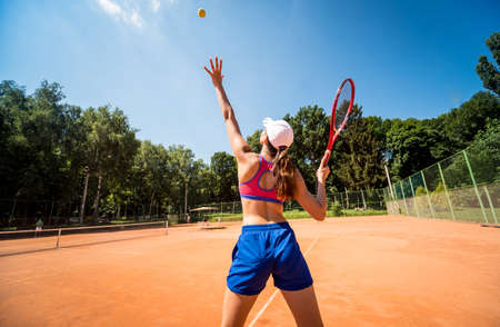 Young athletic woman playing tennis on the court.の写真素材