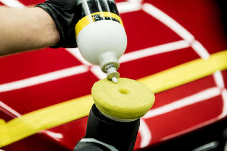 Car service worker polishes a car details with orbital polisher.の写真素材