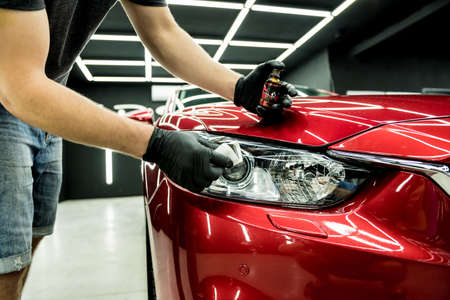 Car service worker applying nano coating on a car detail.の写真素材
