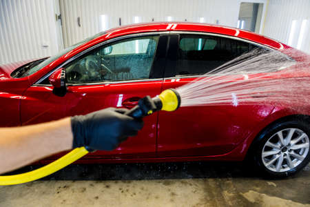 Service worker washing car on a car wash.の写真素材