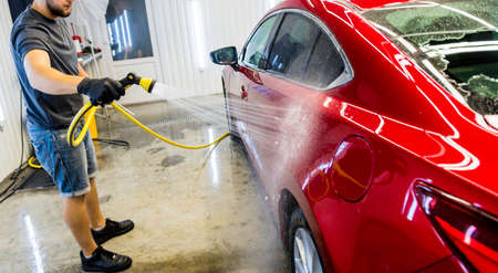 Service worker washing car on a car wash.の写真素材