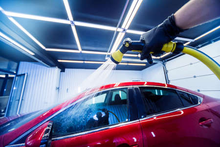Service worker washing car on a car wash.の写真素材