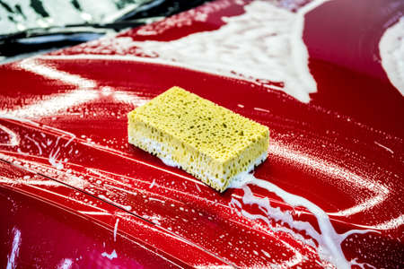 Sponge over the red car for washing.の写真素材