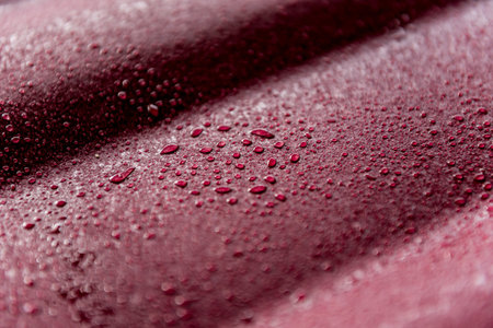 Red metallic roof tiles background with drops of water.