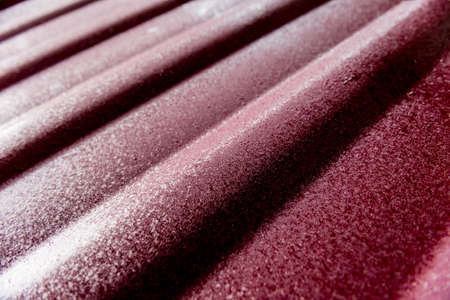 Red metallic roof tiles background with drops of water.の写真素材