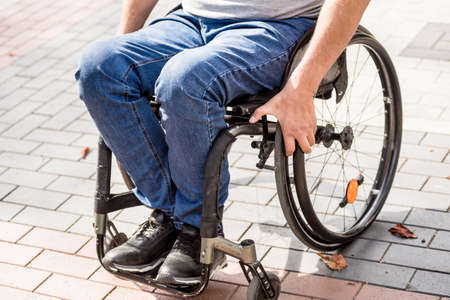 Handicapped man in wheelchair walk at the park alleyの写真素材