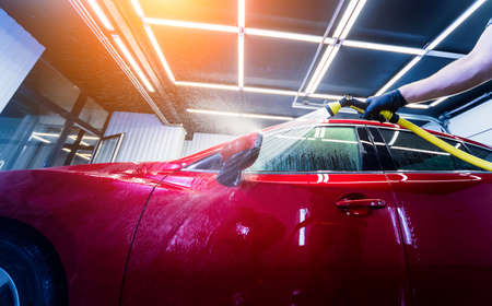 Service worker washing car on a car wash.の写真素材