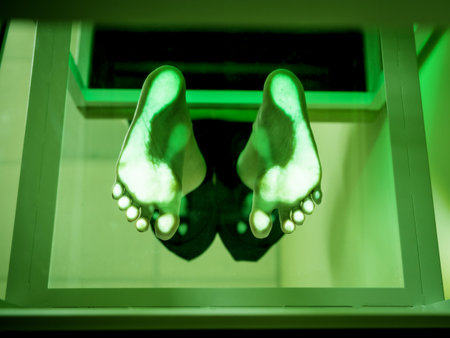 Doctor is at examining womans feet by using plantoscopy deviceの写真素材