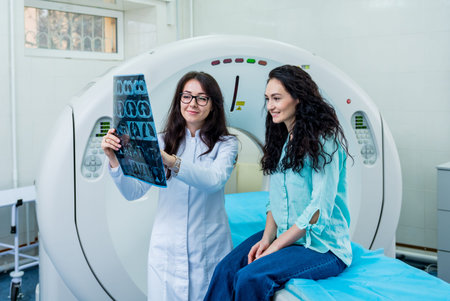 Radiologist with a female patient examining a CT scan