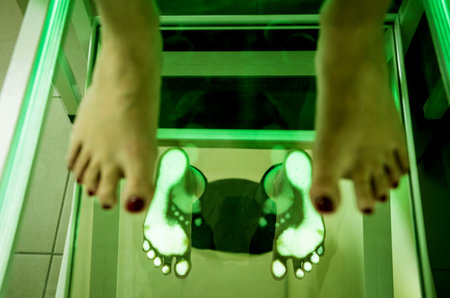 Doctor is at examining womans feet by using plantoscopy device
