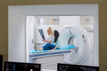 Radiologist with a female patient examining a CT scan