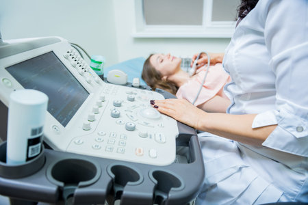 Doctor using ultrasound scanning machine for examining a thyroid of woman