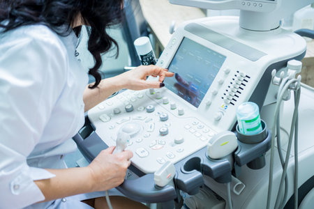 Doctor using ultrasound scanning machine for examining a thyroid of womanの写真素材