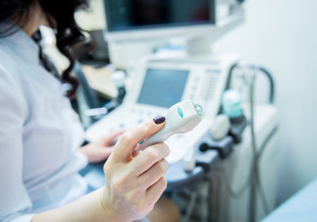 Doctor using ultrasound scanning machine for examining a thyroid of woman