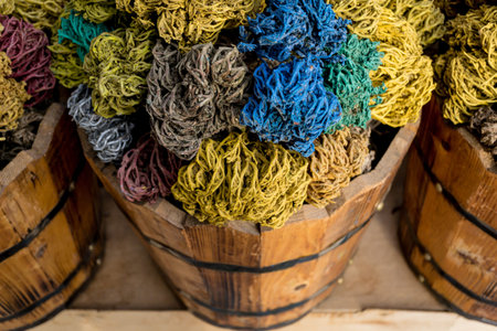 Colored dried seaweed shaped into decorative balls lays in the wooden baskets on the street market