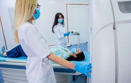 Radiologist with a female patient in the room of computed tomographyの写真素材