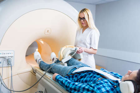 Radiologist prepares the patient for an MRI knee examinationの写真素材
