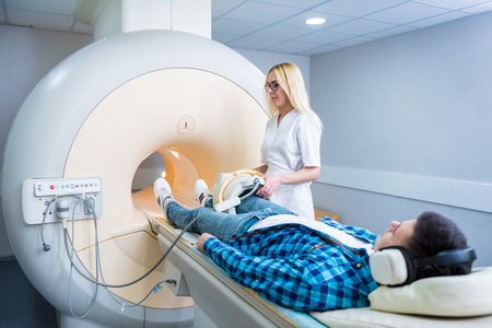 Radiologist prepares the patient for an MRI knee examinationの写真素材