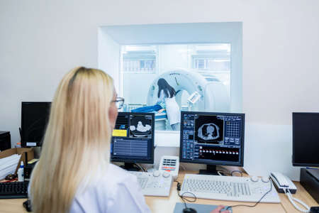 Radiologist in the control room of computed tomography at hospitalの写真素材