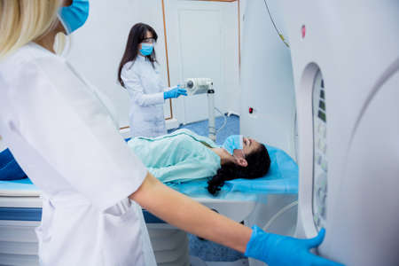 Radiologist with a female patient in the room of computed tomographyの写真素材