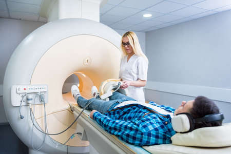 Radiologist prepares the patient for an MRI knee examinationの写真素材