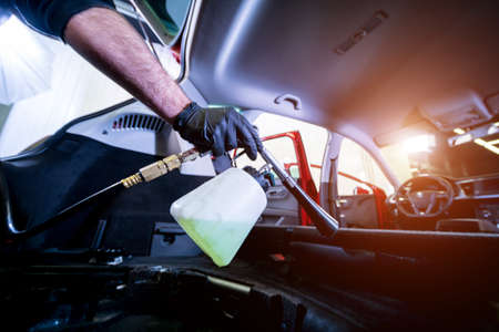 A car service worker cleans interiror with a special foam generatorの写真素材