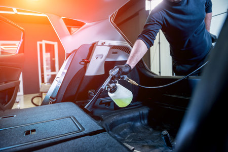 A car service worker cleans interiror with a special foam generatorの写真素材