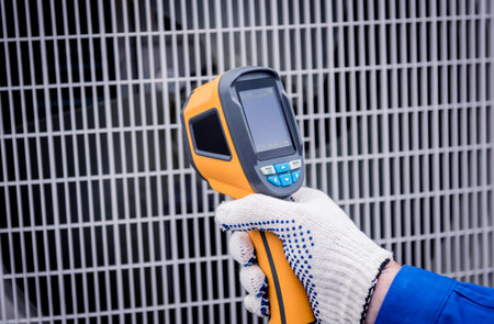 Technician uses a thermal imaging infrared thermometer to check the condensing unit heat exchanger.の写真素材