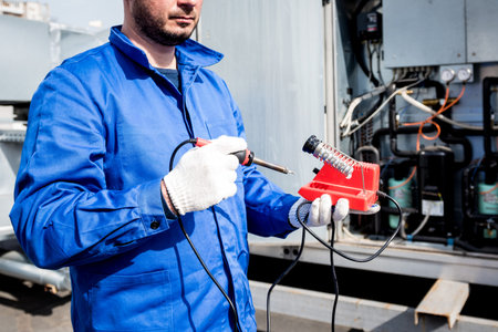 The technician repair electronic temperature sensors with an electronic soldering iron