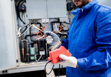 The technician repair electronic temperature sensors with an electronic soldering ironの写真素材