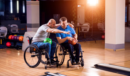 Two young disabled men in wheelchairs playing bowling in the club