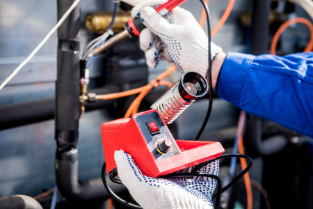 The technician repair electronic temperature sensors with an electronic soldering iron