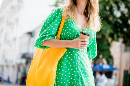 Young beautyful woman with yellow linen eco bag on city background.の写真素材
