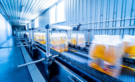 Modern strapping and transporting machine for packaging line at beverage plant.