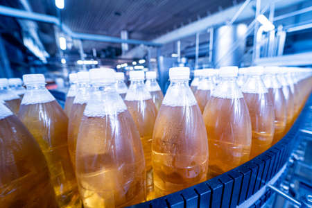 Conveyor belt with bottles for juice or water at a modern beverage plantの写真素材