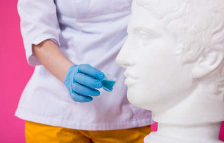 Beautiful girl proposes mouthwash for antique statueの写真素材